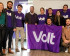 Members of Volt standing together holding up a Volt flag